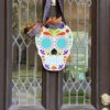 Sugar Skull with blue eyes hanging on a door.