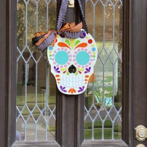 Sugar Skull with blue eyes hanging on a door.